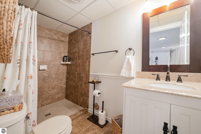 bathroom with toilet, curtained shower, tile patterned flooring, vanity, and a paneled ceiling