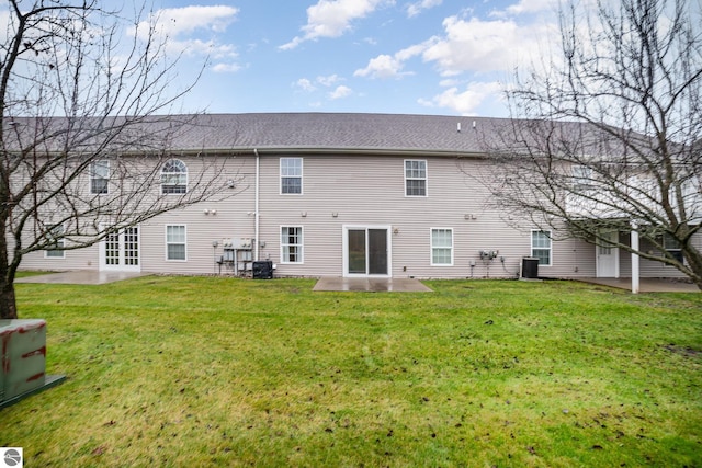 rear view of house featuring central AC, a lawn, and a patio