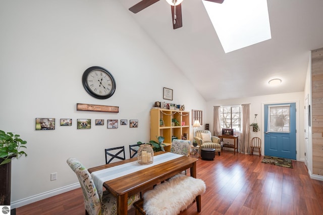 dining room with a skylight, high vaulted ceiling, ceiling fan, and dark hardwood / wood-style flooring