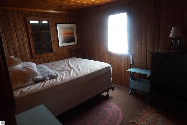 bedroom featuring carpet flooring, wooden walls, multiple windows, and wooden ceiling