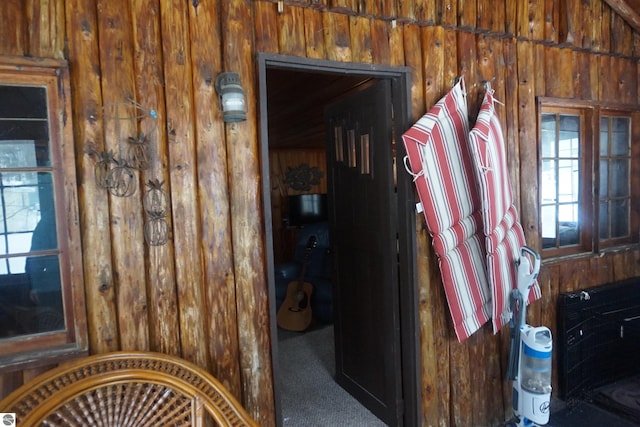 miscellaneous room with wooden walls and carpet floors