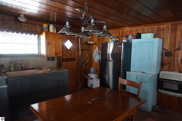 kitchen featuring black refrigerator, sink, heating unit, and wooden ceiling