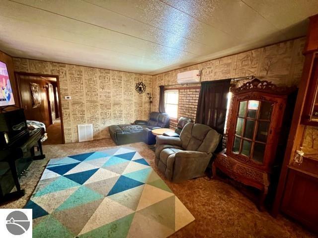 living room with carpet and an AC wall unit