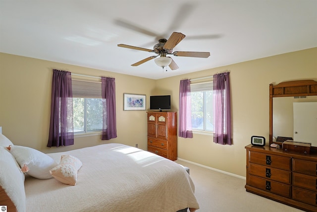 bedroom with ceiling fan and light colored carpet