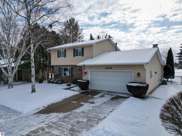 view of front of property featuring a garage and central air condition unit