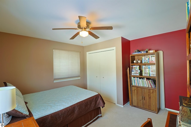 bedroom featuring light colored carpet, a closet, and ceiling fan