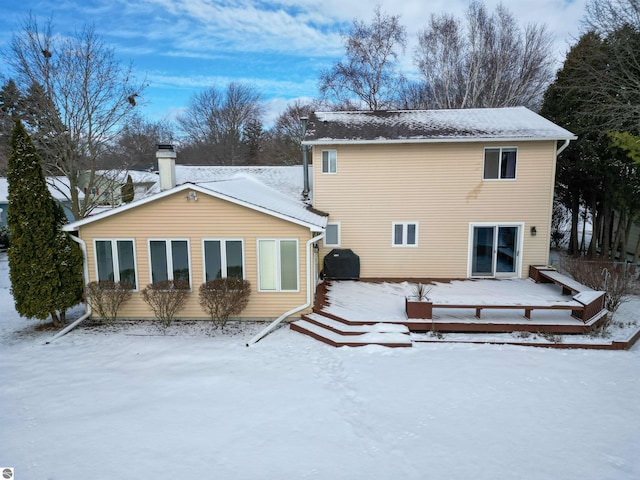 snow covered property featuring a wooden deck