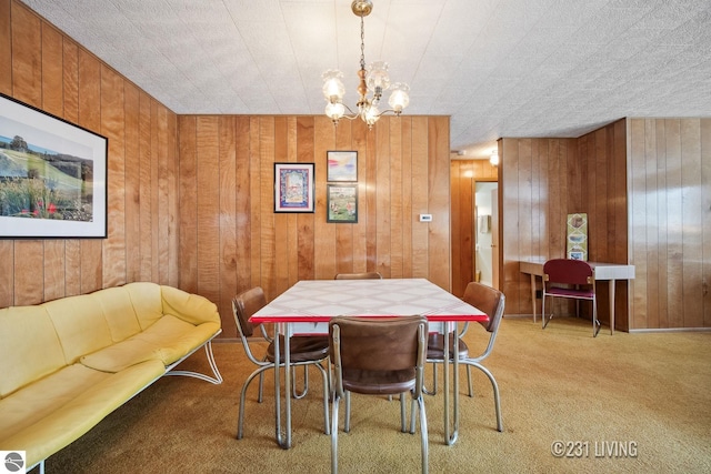 dining area featuring wood walls, light colored carpet, and a notable chandelier