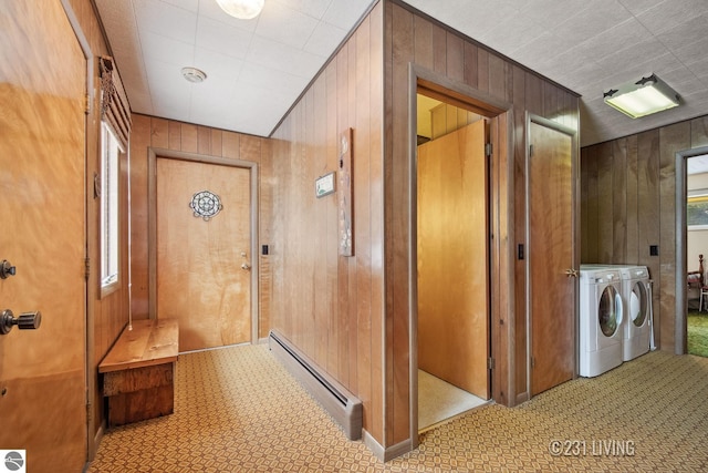 corridor featuring baseboard heating, washer and clothes dryer, and wood walls