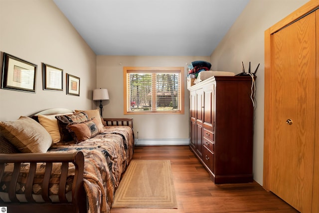 bedroom with a baseboard radiator and dark hardwood / wood-style flooring