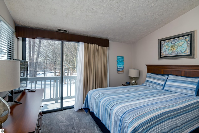 carpeted bedroom with access to exterior, vaulted ceiling, and a textured ceiling