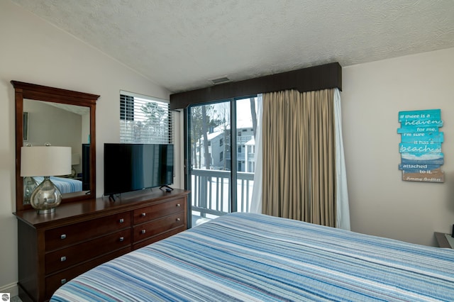 bedroom featuring vaulted ceiling, access to outside, and a textured ceiling