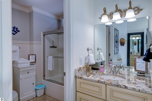 full bathroom featuring tile patterned flooring, enclosed tub / shower combo, ornamental molding, vanity, and toilet