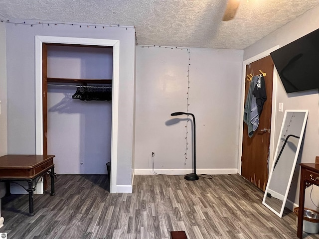 bedroom with ceiling fan, dark hardwood / wood-style floors, a closet, and a textured ceiling