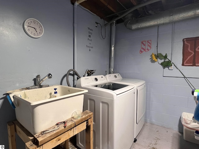 clothes washing area with washing machine and dryer and sink