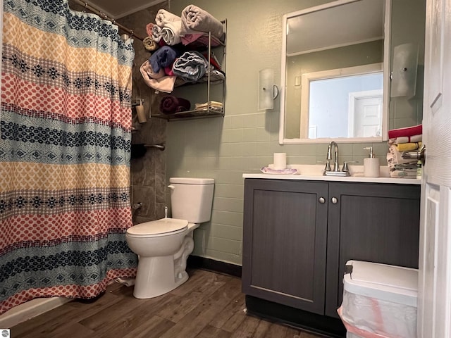 bathroom with a shower with curtain, wood-type flooring, vanity, and toilet