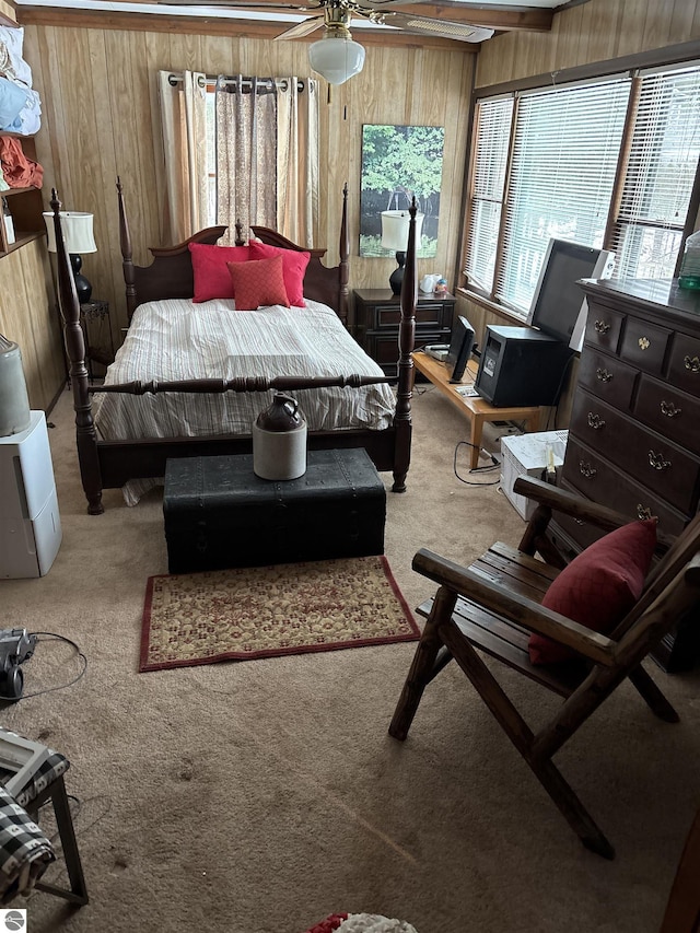 carpeted bedroom featuring wooden walls