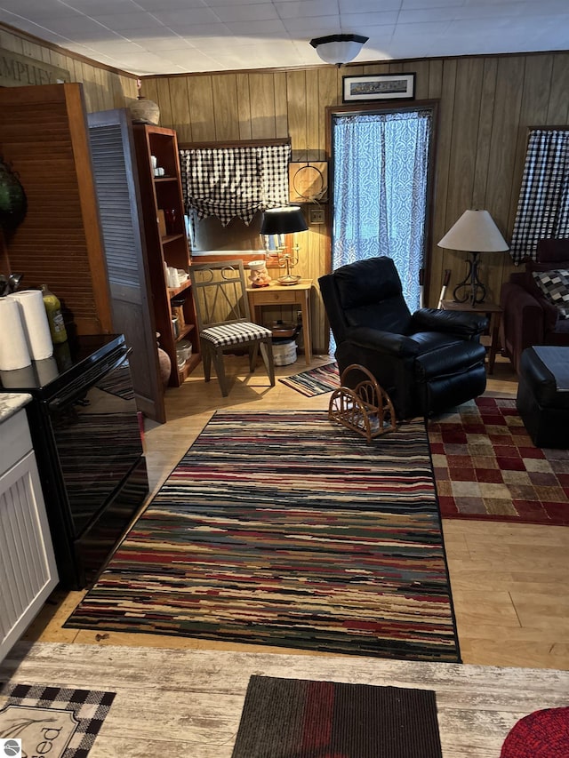 living area with wooden walls and light hardwood / wood-style floors