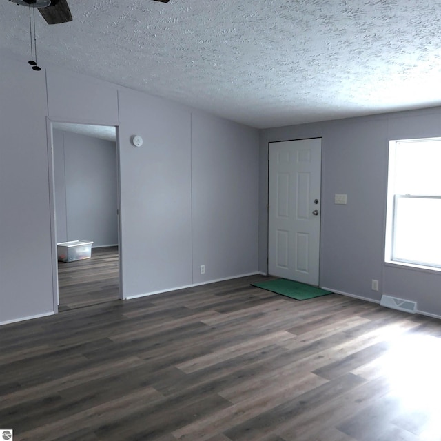 unfurnished room with dark hardwood / wood-style floors and a textured ceiling