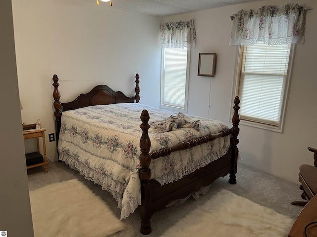 bedroom with light carpet, multiple windows, and a textured ceiling