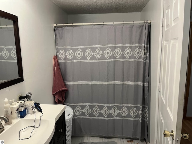 bathroom with vanity, curtained shower, and a textured ceiling