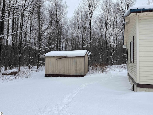 snowy yard with a shed