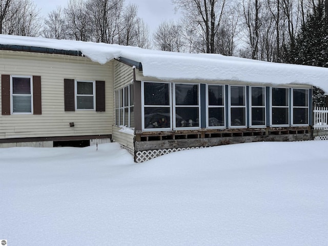 view of snow covered rear of property