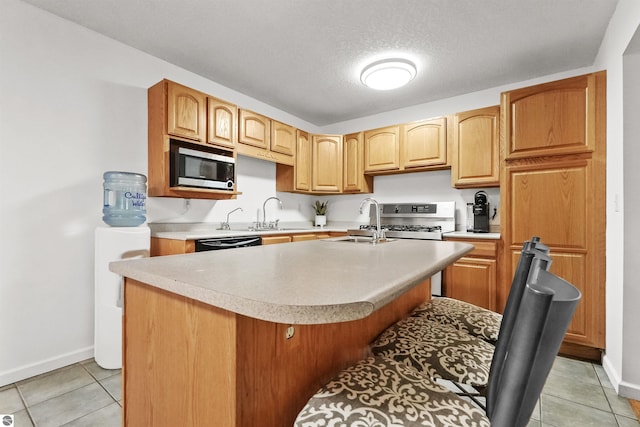 kitchen with an island with sink, appliances with stainless steel finishes, sink, and a textured ceiling