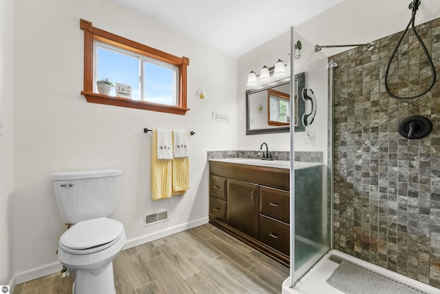 bathroom featuring vanity, walk in shower, and toilet