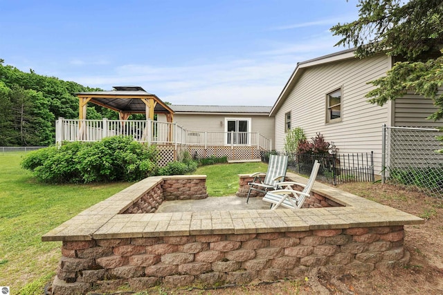 back of property with a fire pit, a gazebo, a lawn, and a patio