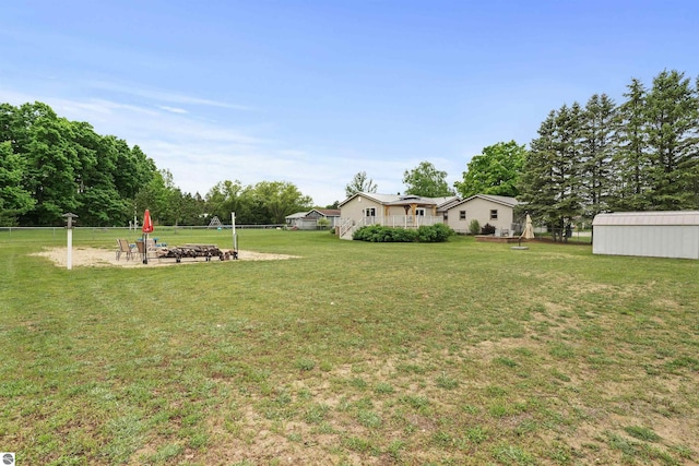 view of yard with a storage shed and an outdoor fire pit