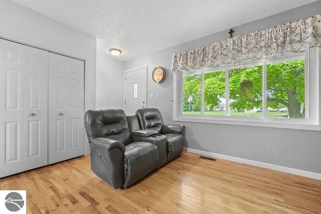 home theater with a healthy amount of sunlight, hardwood / wood-style floors, and a textured ceiling