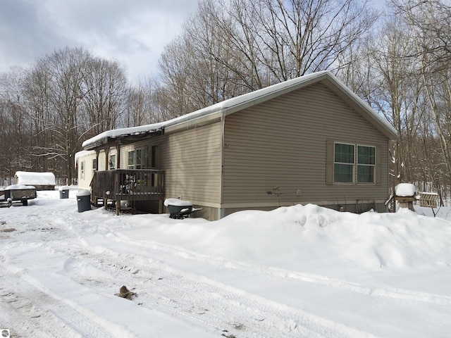 view of snow covered exterior with a deck