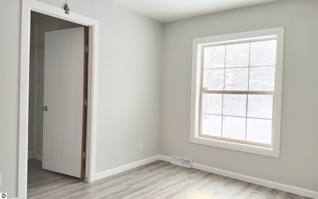 unfurnished room featuring plenty of natural light and light hardwood / wood-style flooring