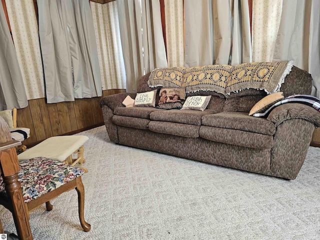 living room featuring wooden walls and light colored carpet