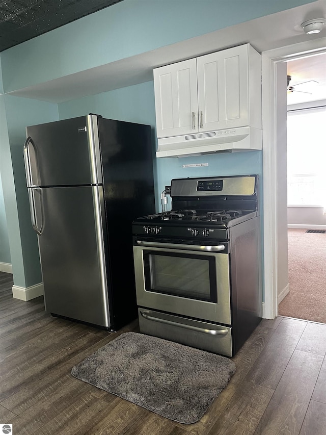 kitchen featuring appliances with stainless steel finishes, dark wood-type flooring, and white cabinets