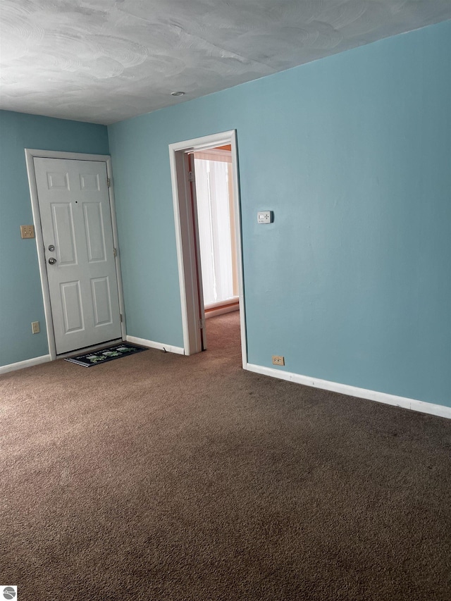 empty room featuring carpet floors and a textured ceiling