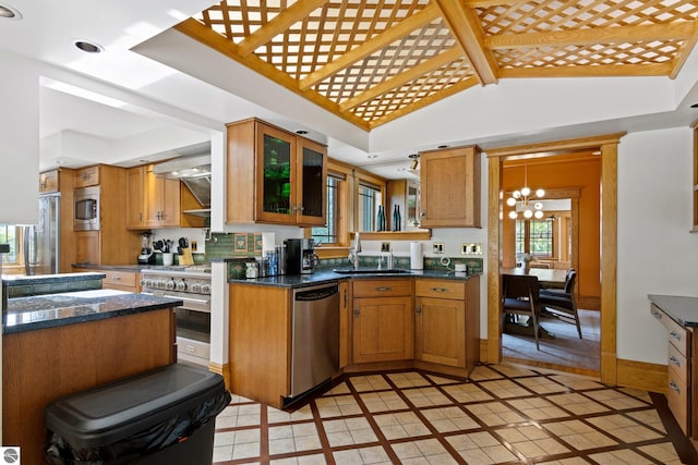 kitchen with light tile patterned flooring, sink, a notable chandelier, kitchen peninsula, and stainless steel appliances