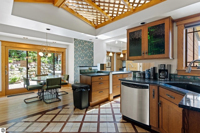 kitchen featuring sink, hanging light fixtures, stainless steel dishwasher, light tile patterned floors, and an inviting chandelier