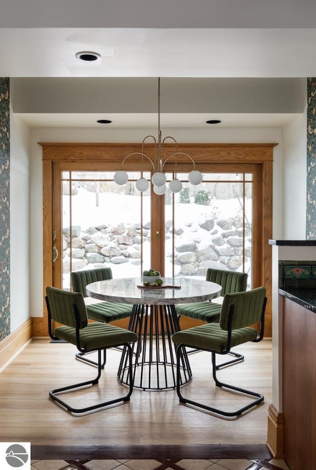 dining room with hardwood / wood-style flooring, an inviting chandelier, and a wealth of natural light