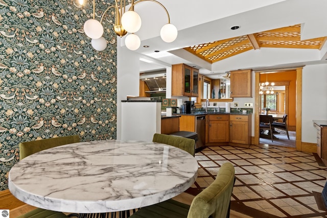 dining area with a notable chandelier, sink, and vaulted ceiling with beams