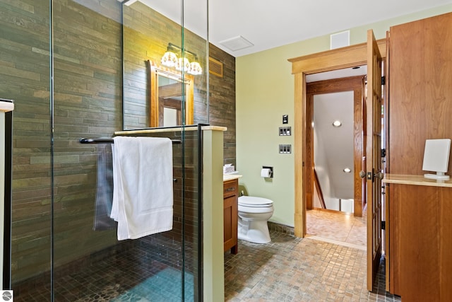 bathroom featuring vanity, toilet, and a shower with shower door