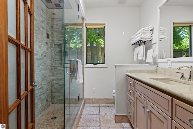 bathroom with walk in shower, vanity, and toilet