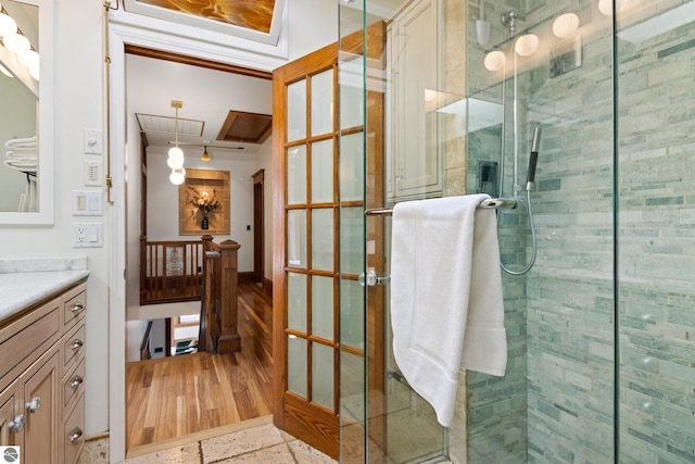 bathroom featuring a shower with door and vanity