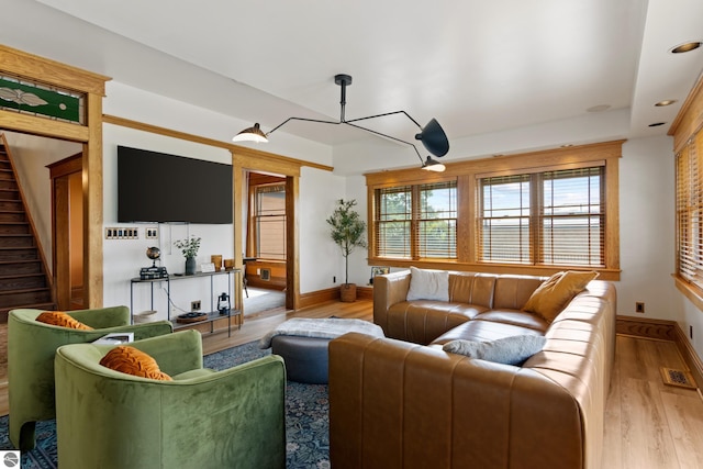 living room featuring a raised ceiling and light wood-type flooring