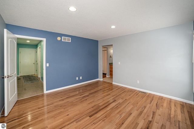 unfurnished bedroom featuring a textured ceiling and light wood-type flooring