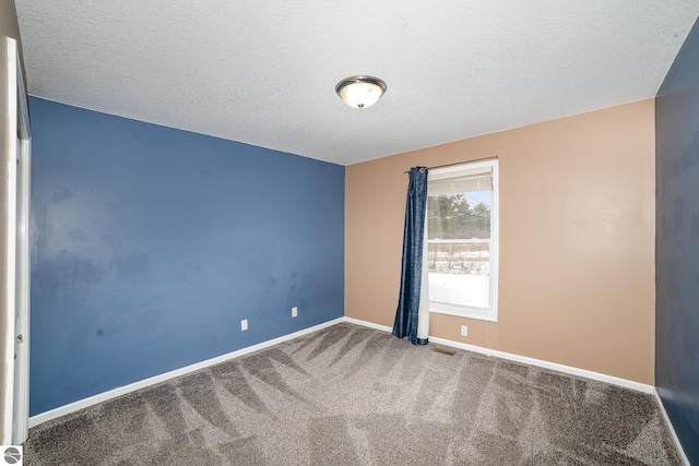 unfurnished room featuring carpet floors and a textured ceiling