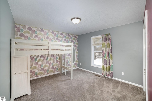 unfurnished bedroom featuring a textured ceiling and carpet