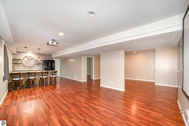 unfurnished living room with hardwood / wood-style floors and a textured ceiling