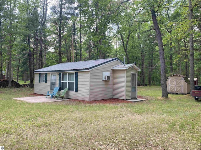 view of front of home featuring a storage shed, a front lawn, and a patio